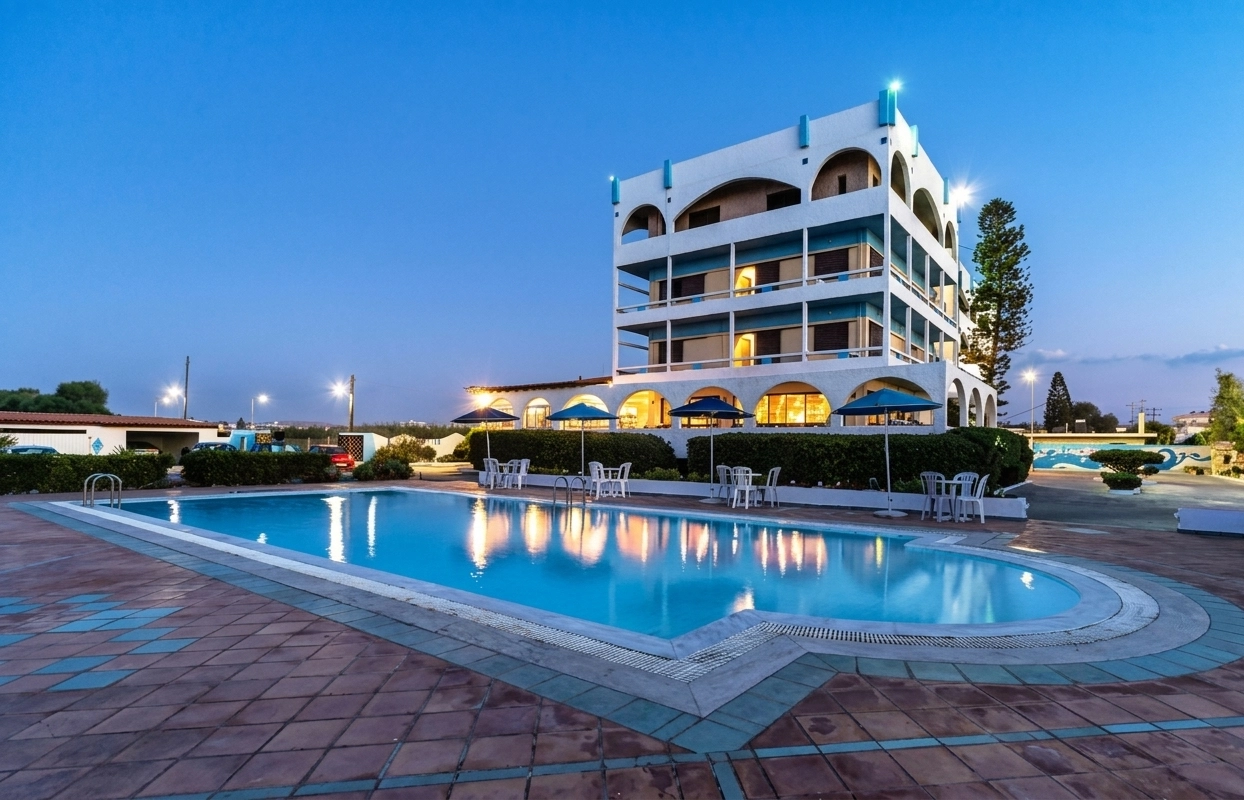 Outdoor pool and sun terrace at Hotel Tsagarakis Beach at dusk